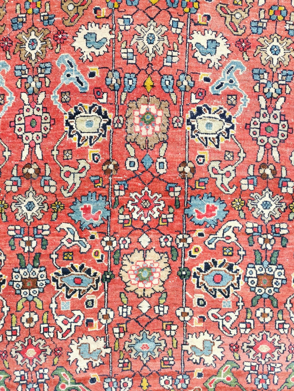 A rectangular hand-knotted Persian Bijar rug displaying a dense floral pattern across a red field bordered by navy blue decorative banding. View II