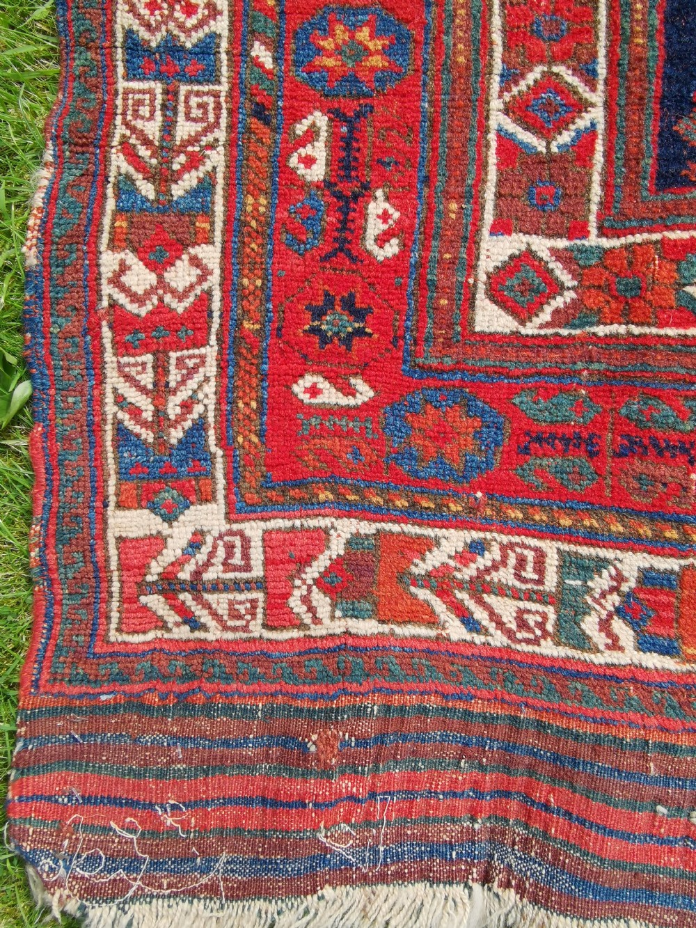 A hand-knotted antique Afshar wool rug featuring a geometric diamond lattice pattern in crimson red and navy blue with detailed borders. View III