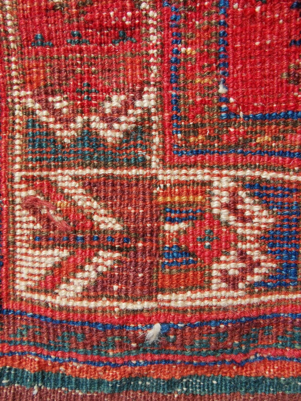 A hand-knotted antique Afshar wool rug featuring a geometric diamond lattice pattern in crimson red and navy blue with detailed borders. View IV