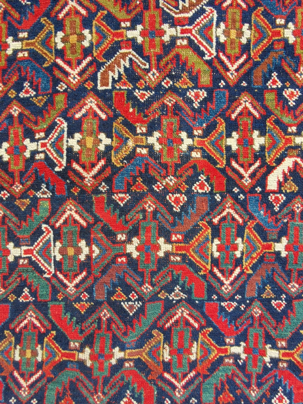 A hand-knotted antique Afshar wool rug featuring a geometric diamond lattice pattern in crimson red and navy blue with detailed borders. View VI