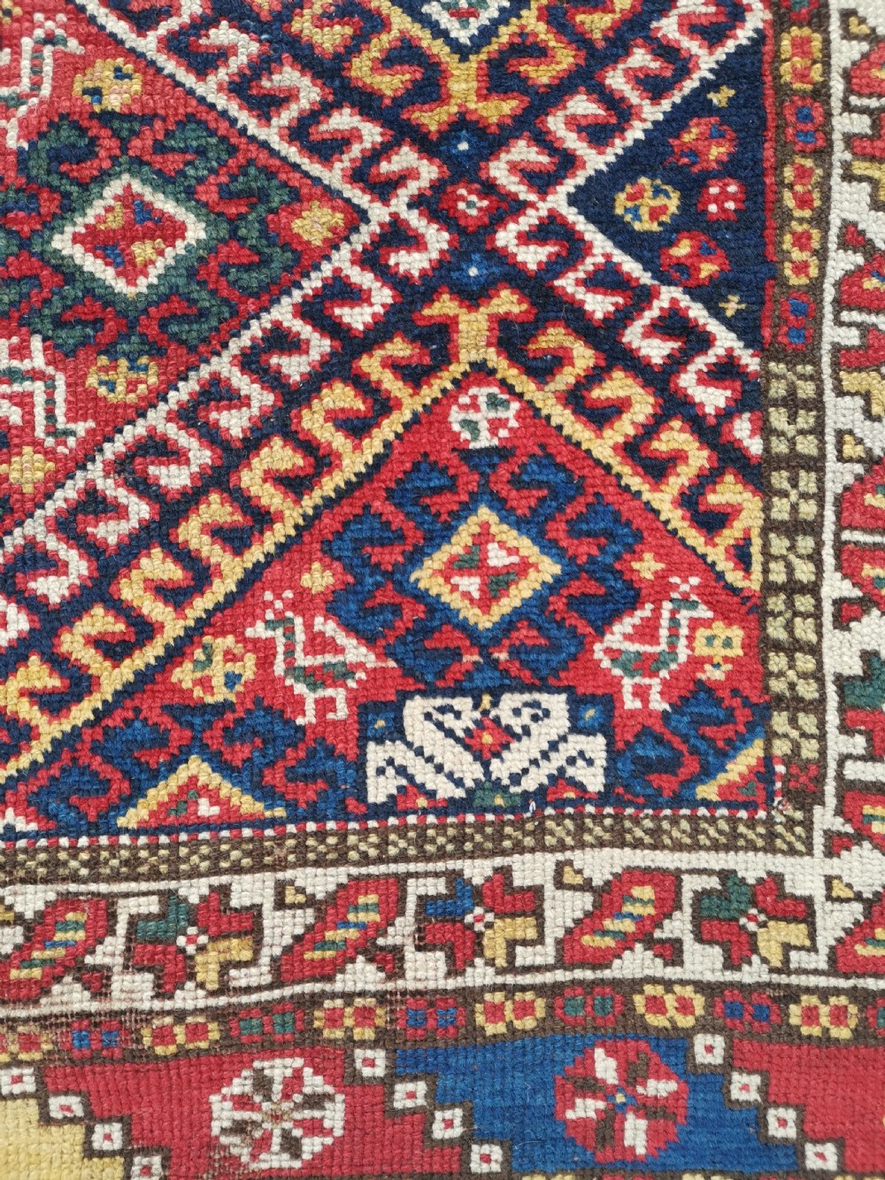 An antique Persian Luri hand-knotted wool runner featuring central diamond medallions in red and navy blue framed by geometric borders. View VI