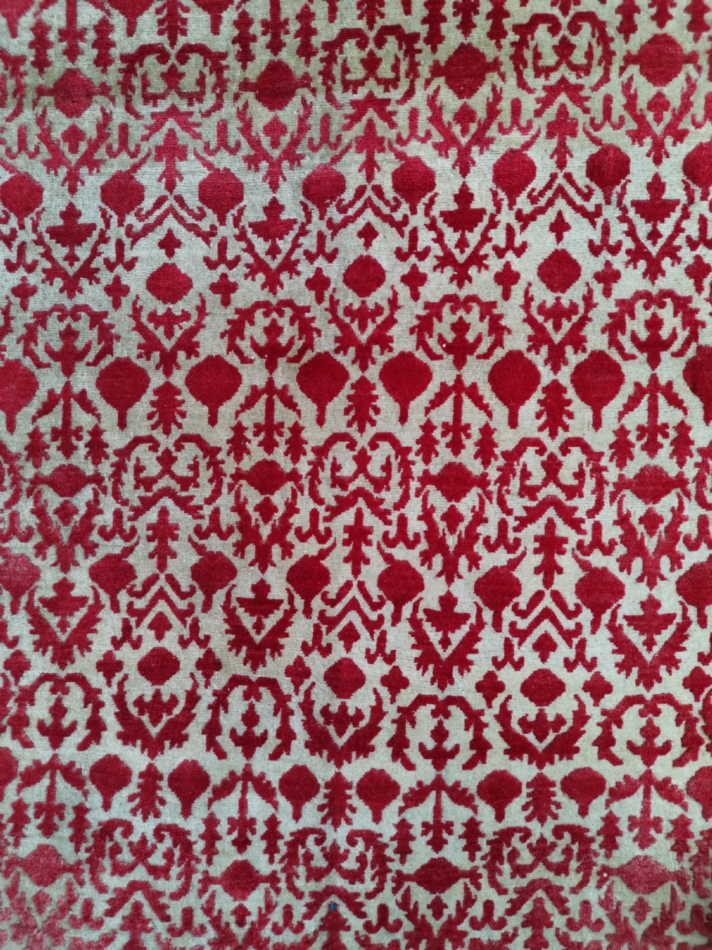 A hand-knotted rectangular antique Sarouk wool rug featuring a crimson red repeating floral pattern on a cream ground framed by a dark floral border. View II