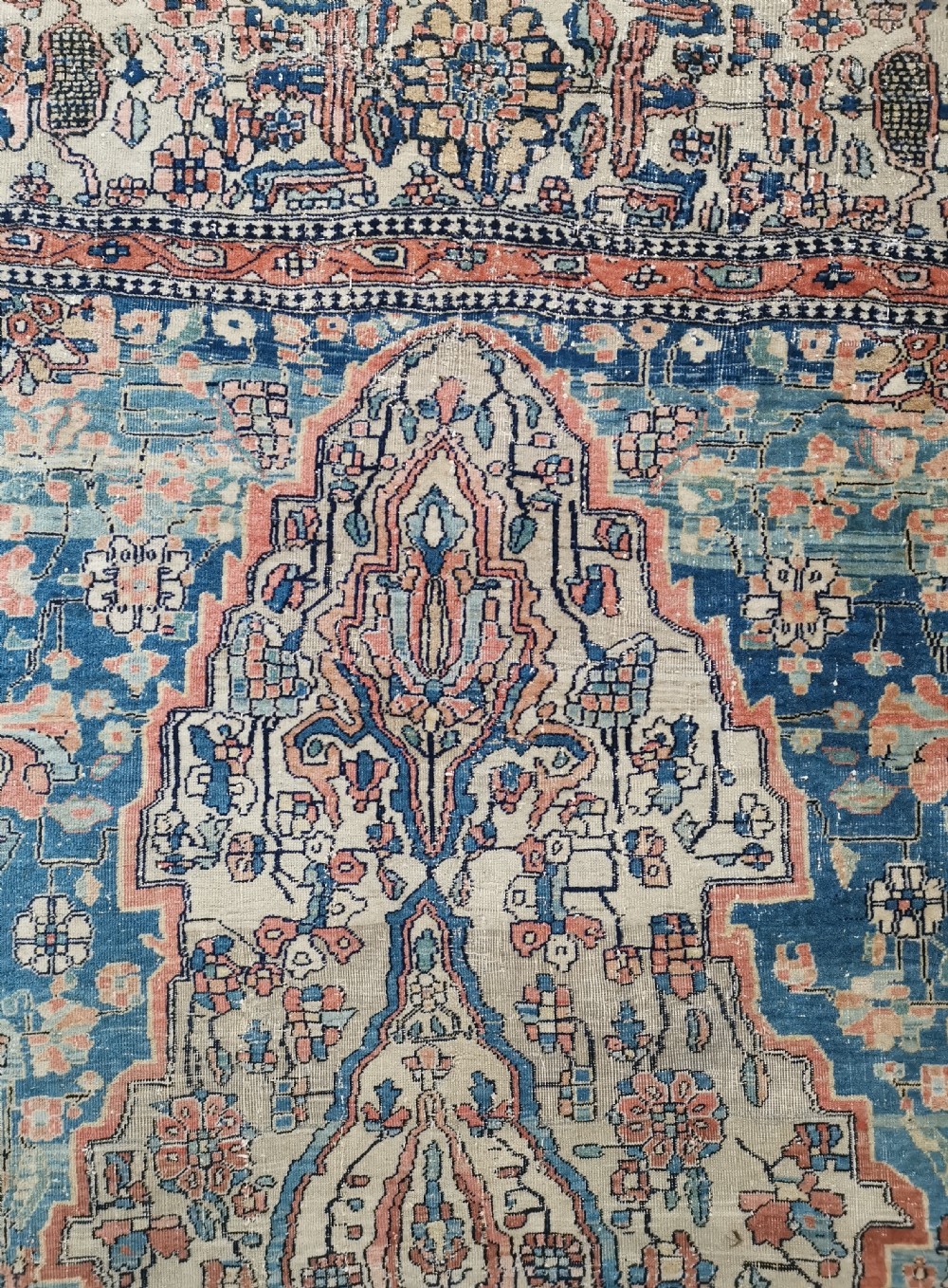 An antique hand-knotted Kashan Persian rug featuring a central blue medallion on a cream field with detailed floral borders. View III