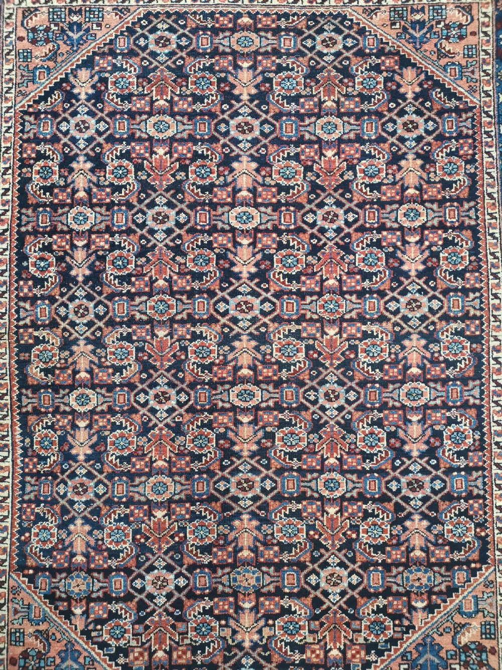 A hand-knotted antique Persian Hamadan wool rug featuring a navy blue field with geometric repeats framed by a terracotta spandrel and detailed multi-band border. View II