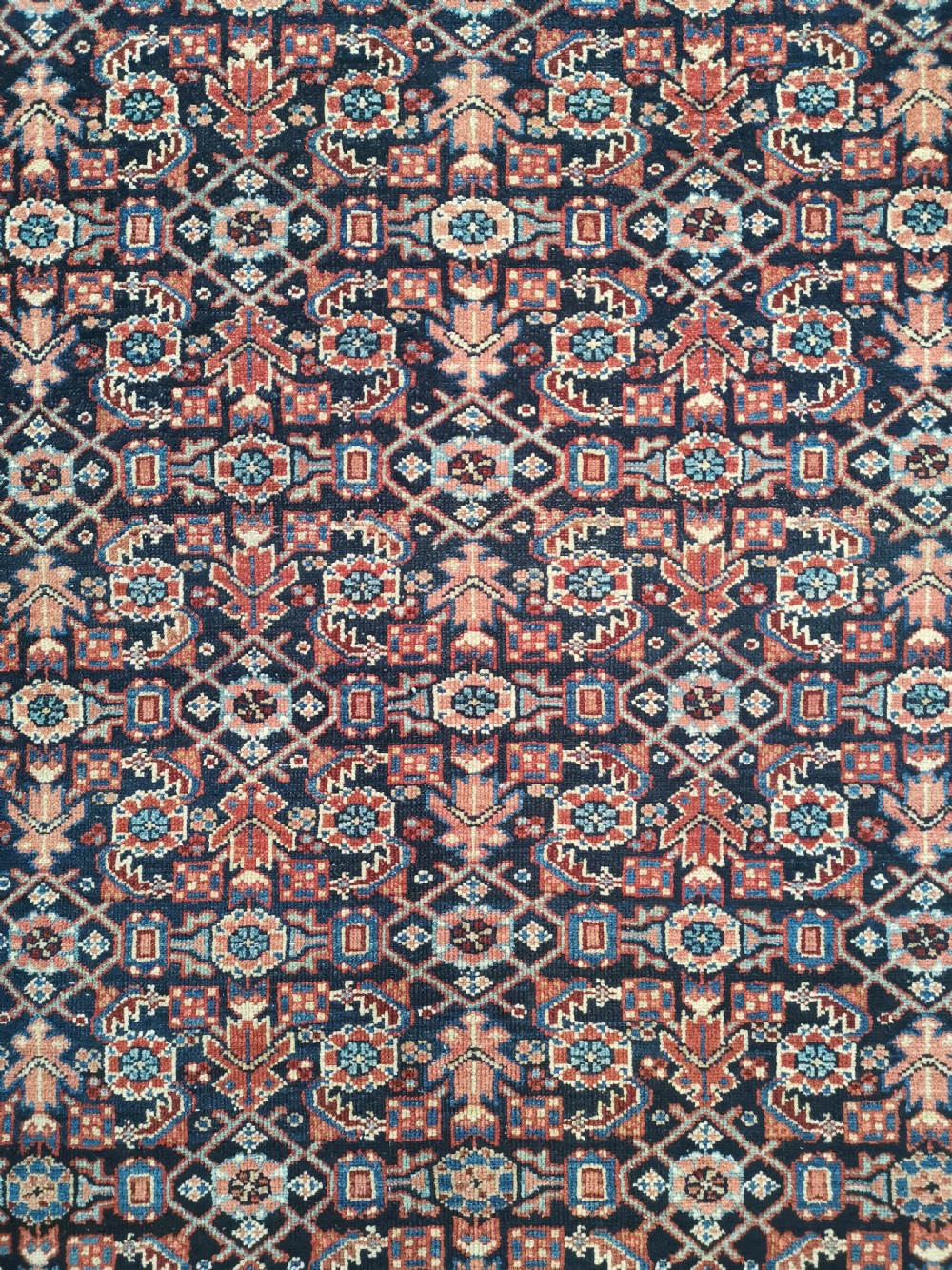 A hand-knotted antique Persian Hamadan wool rug featuring a navy blue field with geometric repeats framed by a terracotta spandrel and detailed multi-band border. View III