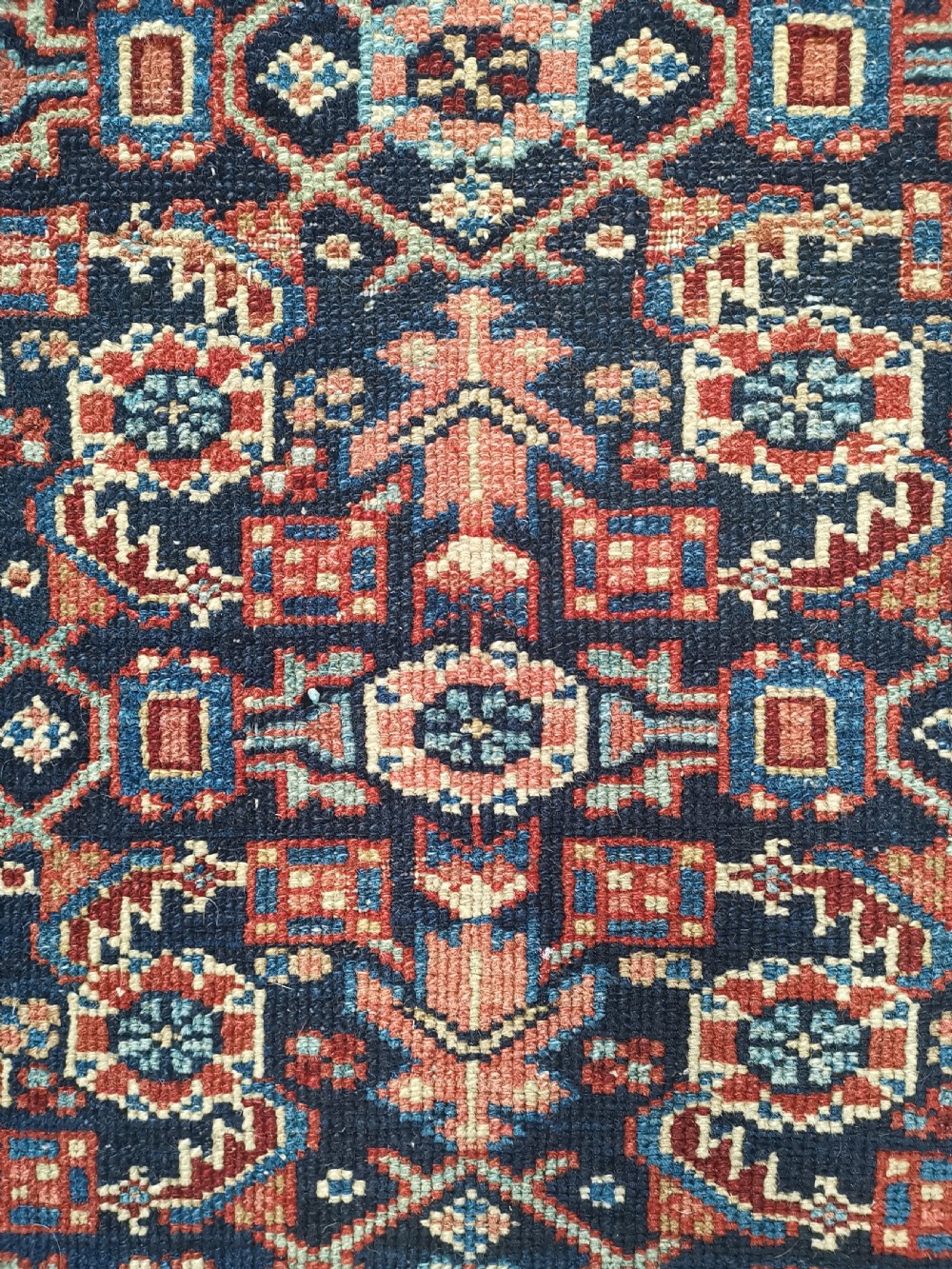 A hand-knotted antique Persian Hamadan wool rug featuring a navy blue field with geometric repeats framed by a terracotta spandrel and detailed multi-band border. View IV