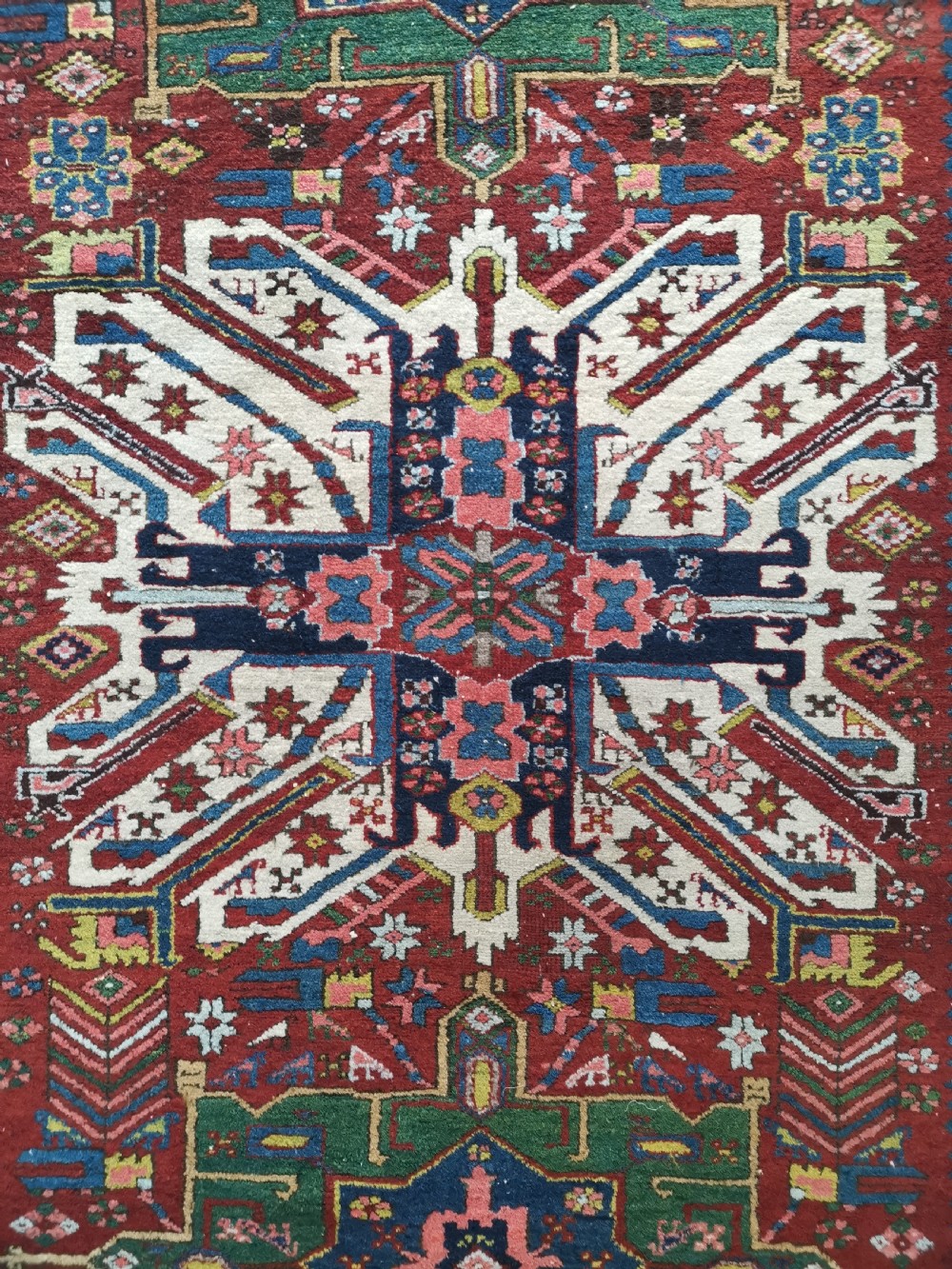 A hand-knotted antique Karaja wool rug featuring an ivory and navy geometric central medallion flanked by smaller star motifs on a deep red field with multi-coloured borders. View II