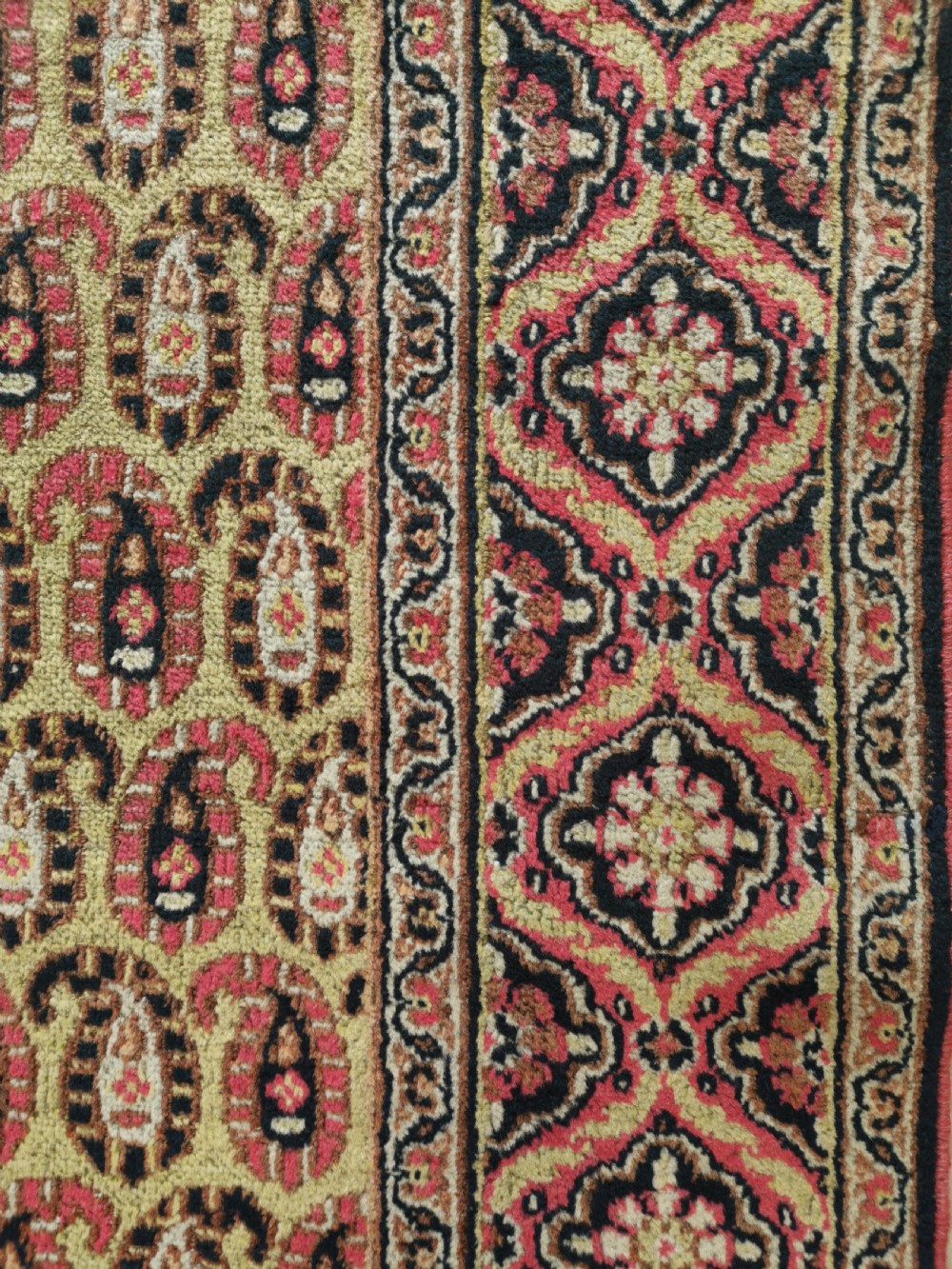 A rectangular hand-knotted Khorassan rug featuring a repeating red boteh pattern on a light yellow field, bordered by a dark floral rosette frame. View II