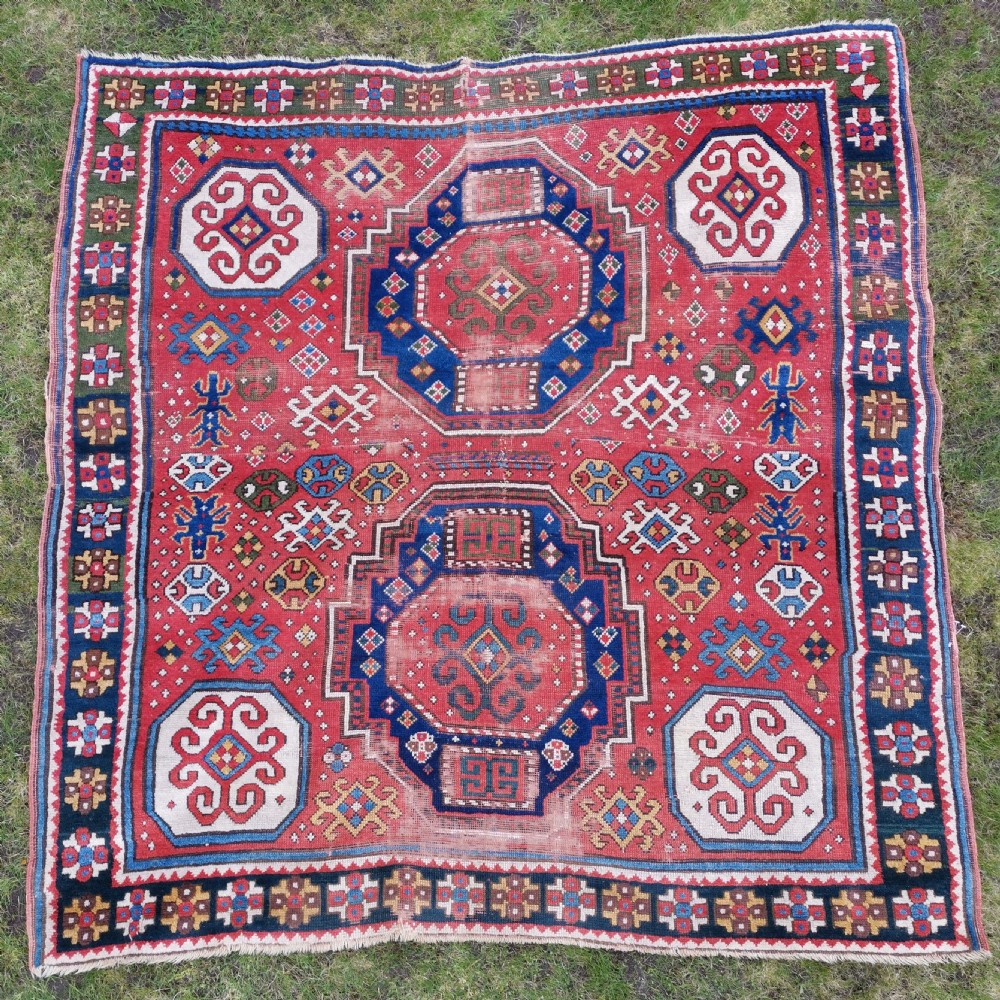 An antique Caucasian Lori Pambak hand-knotted wool rug featuring large octagonal medallions on a bold red field with geometric borders.