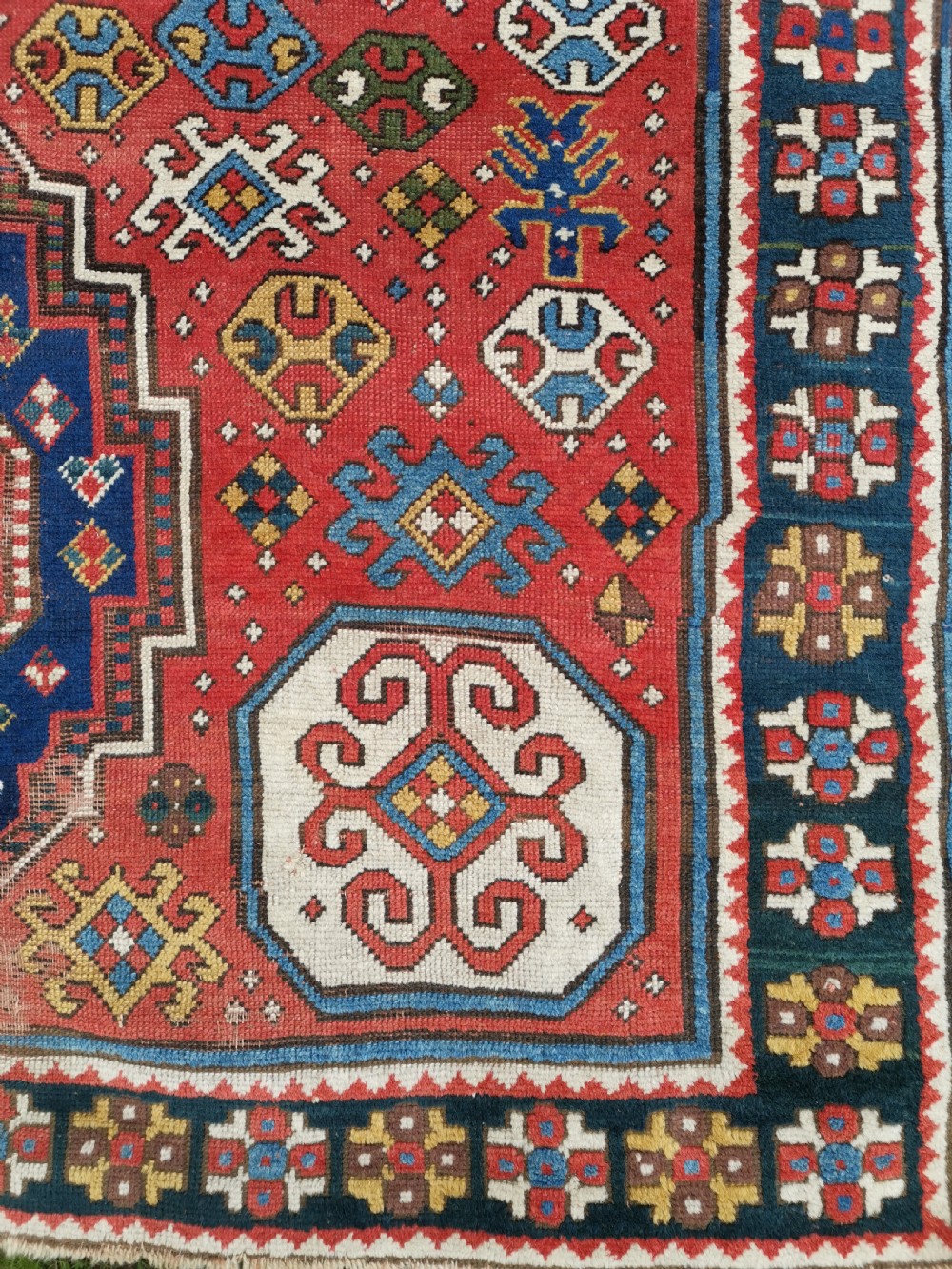 An antique Caucasian Lori Pambak hand-knotted wool rug featuring large octagonal medallions on a bold red field with geometric borders. View II