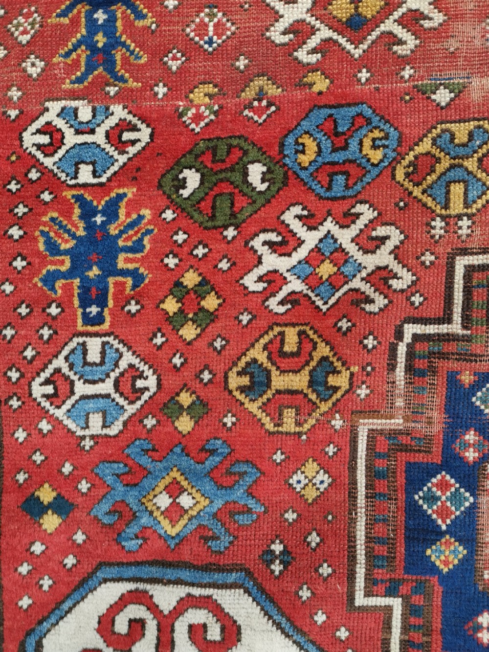 An antique Caucasian Lori Pambak hand-knotted wool rug featuring large octagonal medallions on a bold red field with geometric borders. View IV