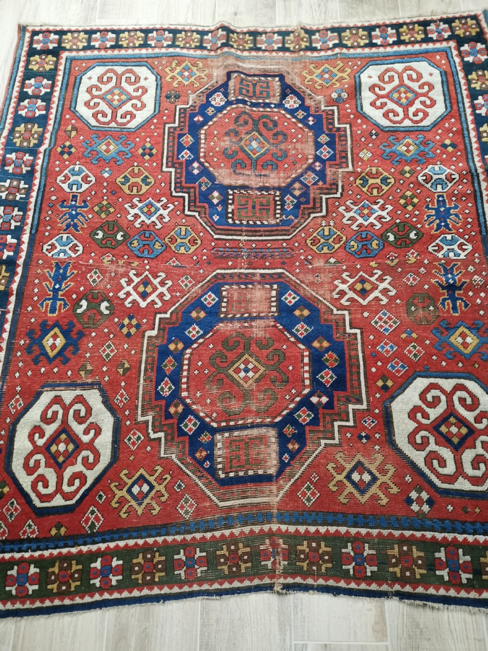 An antique Caucasian Lori Pambak hand-knotted wool rug featuring large octagonal medallions on a bold red field with geometric borders. View VI