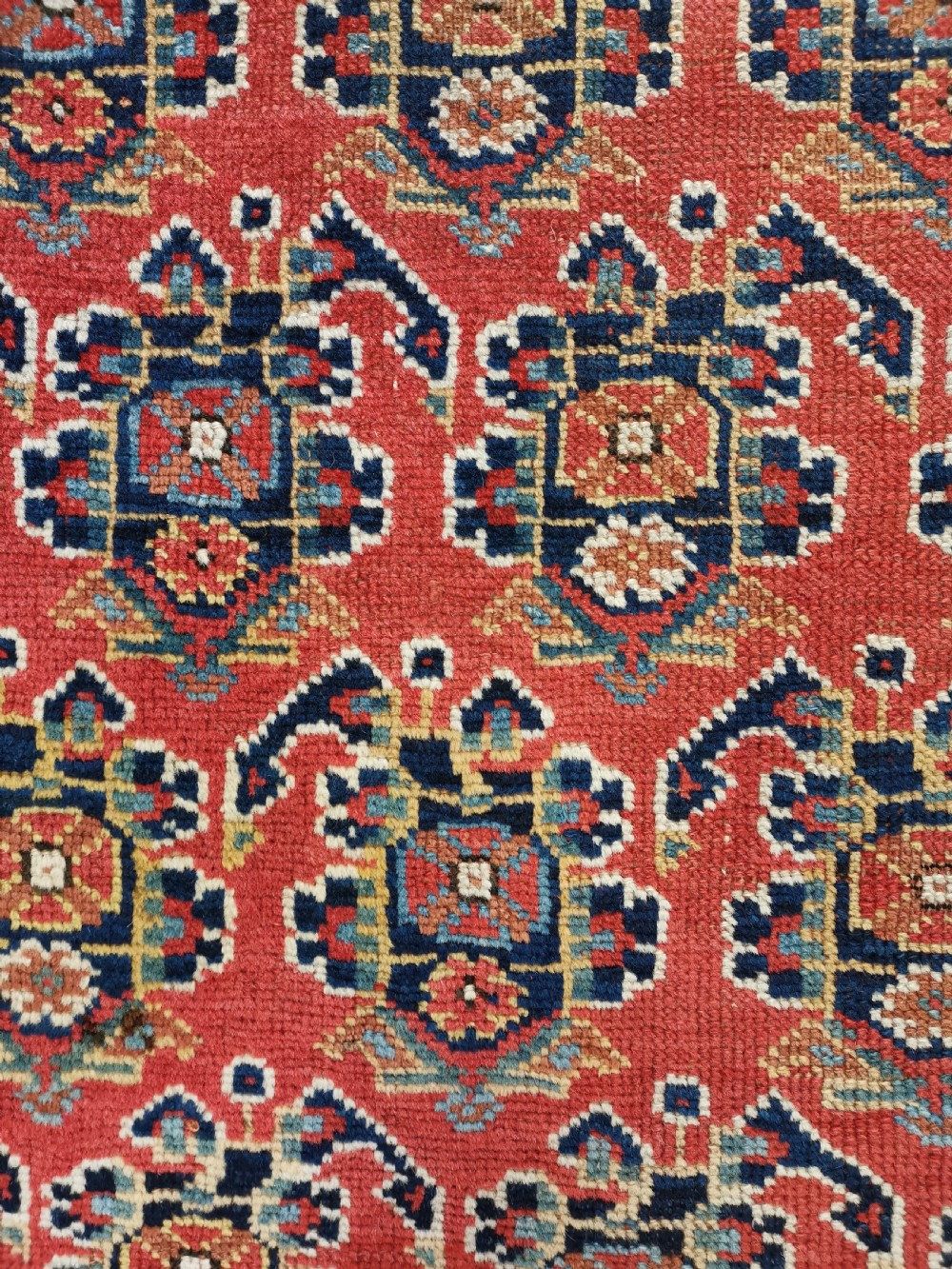 An antique hand-knotted Persian Afshar wool rug featuring a repeating geometric pattern on a deep red field framed by multi-banded borders and flat-woven ends. View V