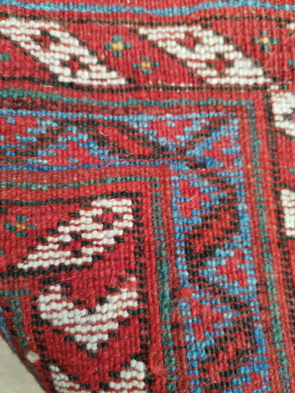 An antique hand-knotted Persian Afshar wool rug featuring a repeating geometric pattern on a deep red field framed by multi-banded borders and flat-woven ends. View VI