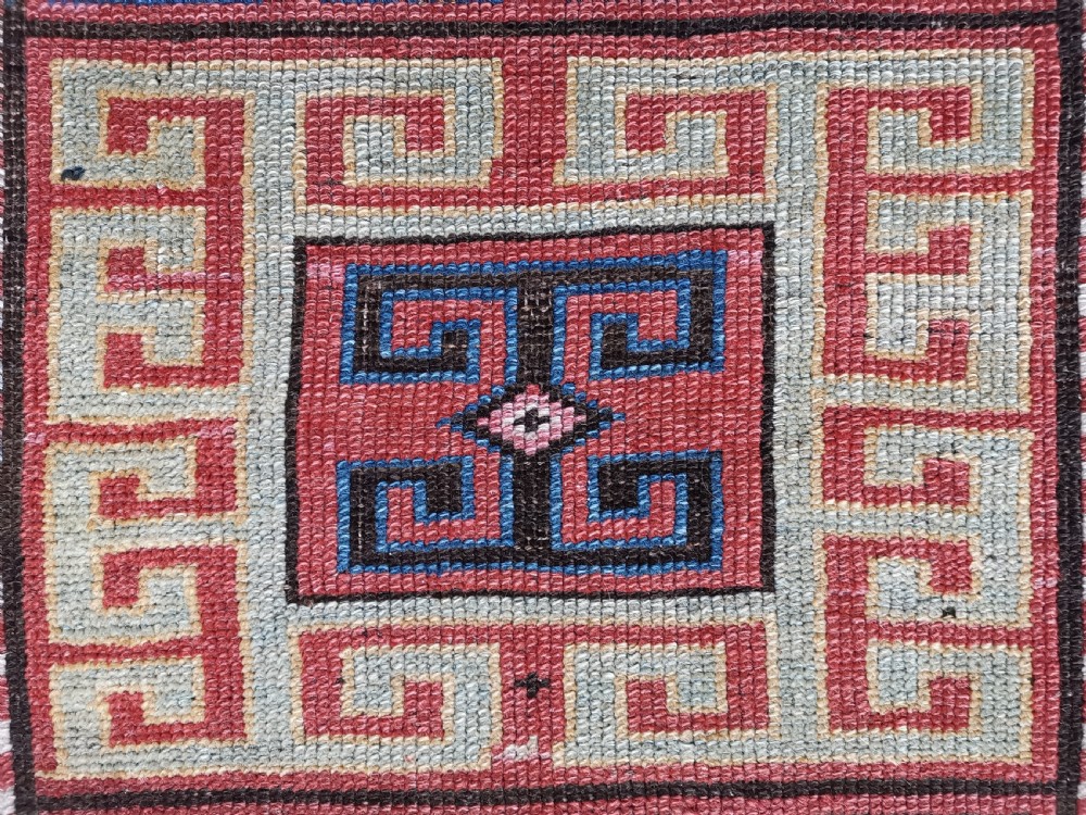 An antique Caucasian Gendje hand-knotted wool runner rug featuring geometric medallions, latch-hook motifs, and a multi-coloured palette of red, blue, yellow, and cream on a dark field. View V