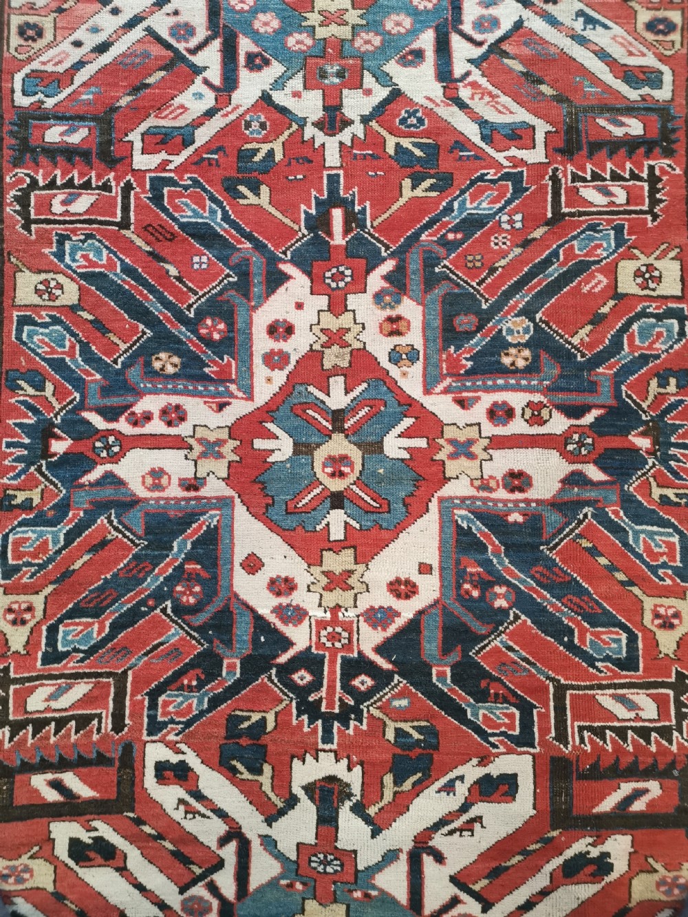 A rectangular hand-knotted Caucasian Chelaberd rug featuring prominent sunburst medallions in red, navy blue, and ivory with geometric borders. View II