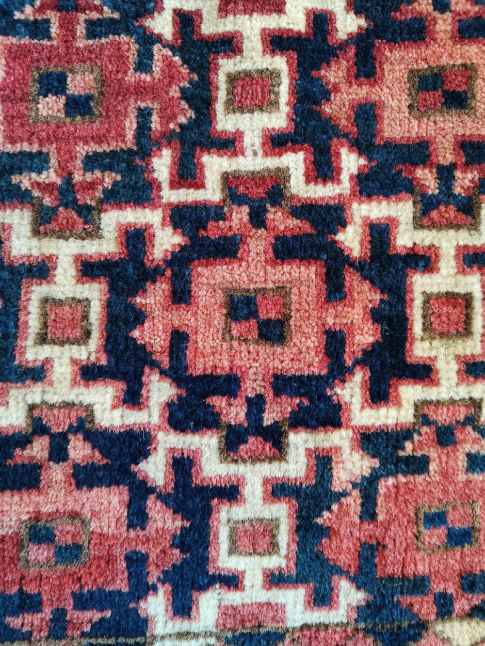 A long, rectangular hand-knotted Ersari torba textile displaying repeating geometric red, navy blue, and cream motifs framed by a narrow patterned border. View IV