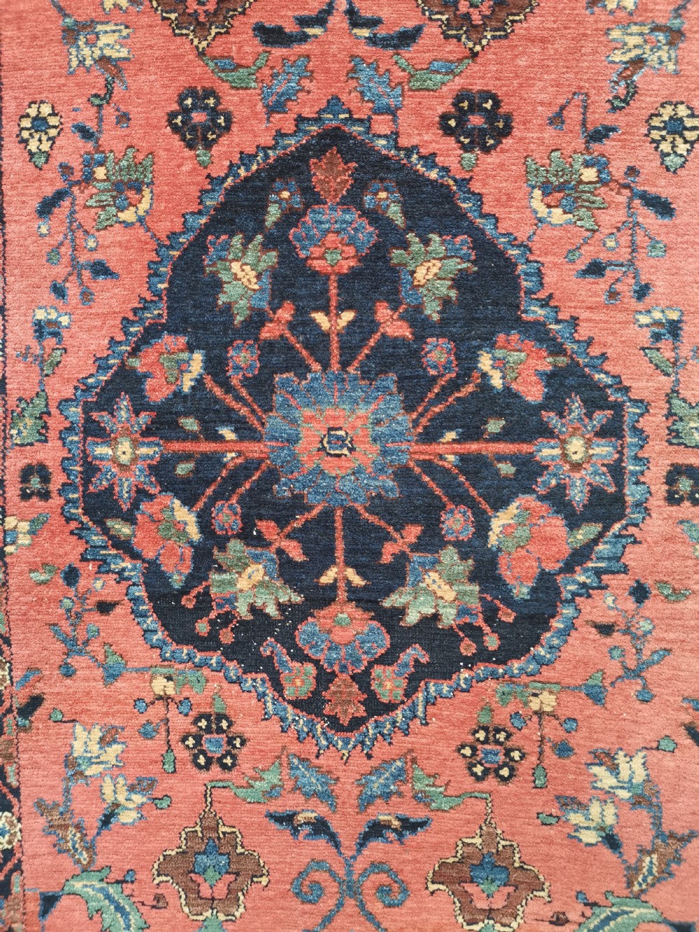 A hand-knotted antique Persian Hamadan rug featuring a central navy blue medallion on a red field framed by patterned borders. View II