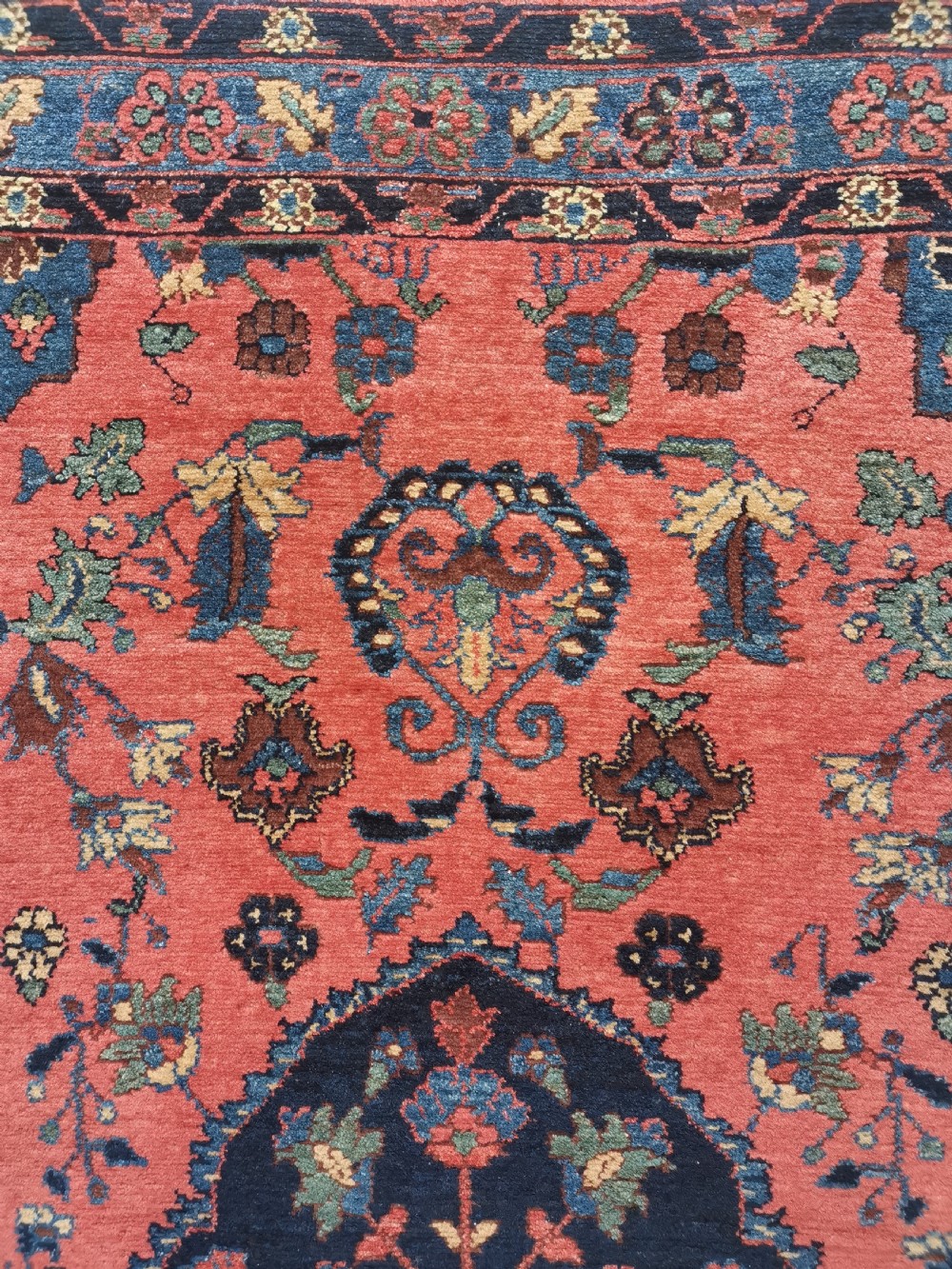 A hand-knotted antique Persian Hamadan rug featuring a central navy blue medallion on a red field framed by patterned borders. View III