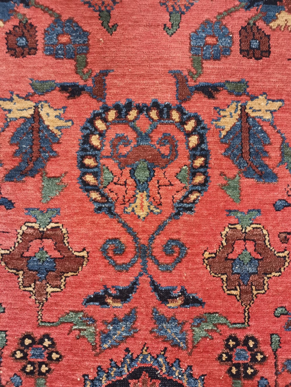 A hand-knotted antique Persian Hamadan rug featuring a central navy blue medallion on a red field framed by patterned borders. View VII