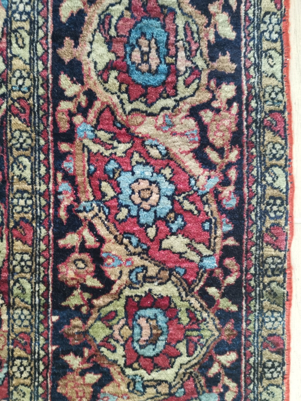 A rectangular hand-knotted Persian Isfahan rug featuring a central medallion with intricate floral arabesques in navy, deep red, and beige tones. View VI