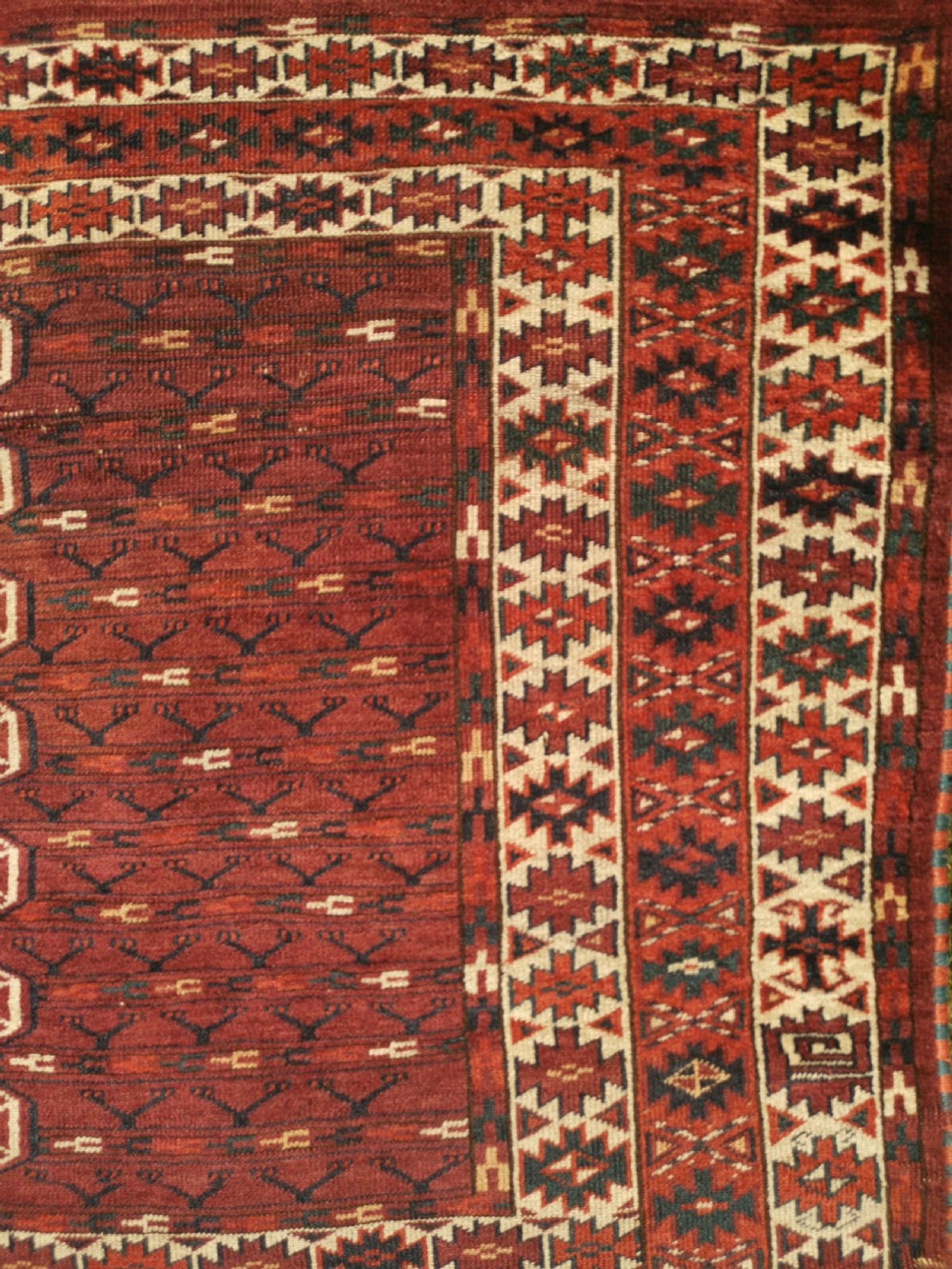 A hand-knotted dark red Yomud Engsi wool rug featuring a cruciform central pattern, geometric borders, and a patterned lower elem skirt. View VI