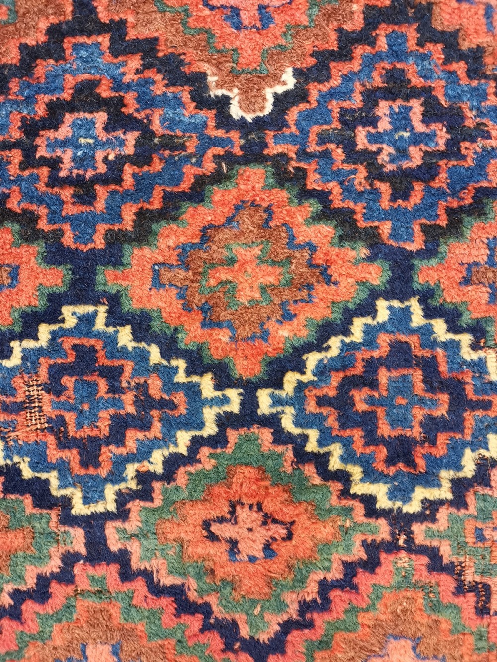 An antique Shahsavan handwoven wool runner featuring a red and navy blue geometric diamond lattice pattern surrounded by multi-coloured borders. View VI