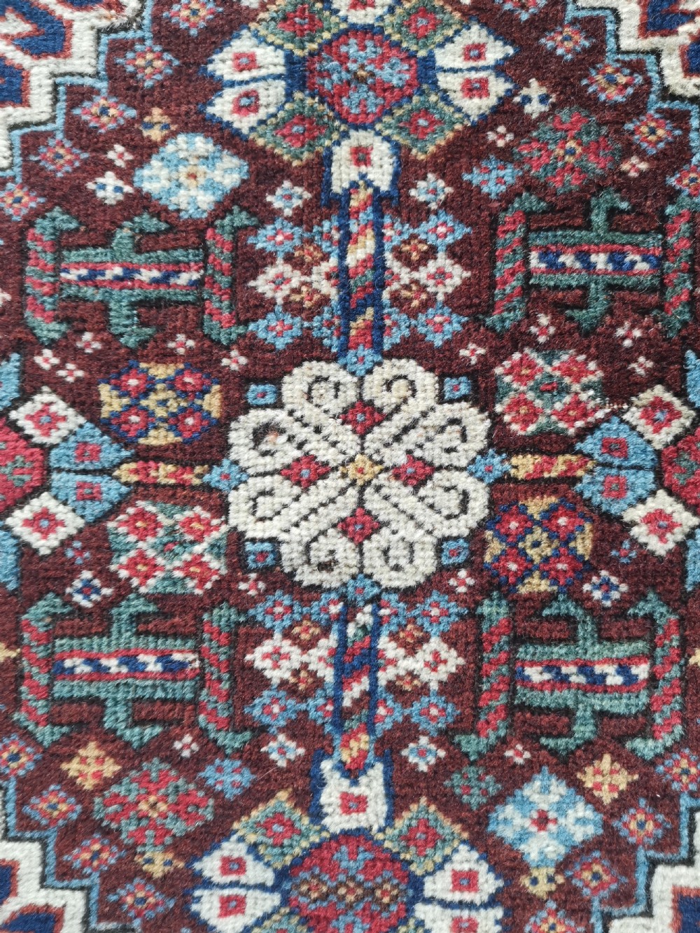 A square hand-knotted wool Qashqai bagface featuring a central geometric diamond medallion surrounded by patterned borders in red, navy blue, and cream shades. View III