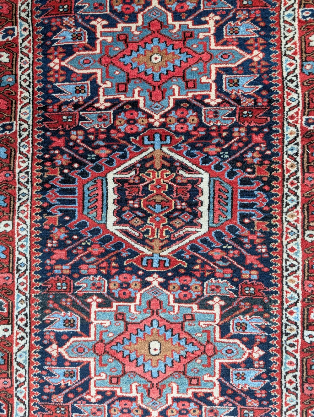A pair of hand-knotted wool Karaja rugs featuring traditional geometric central medallions in blue, red, and ivory on an indigo field with stylized borders. View II