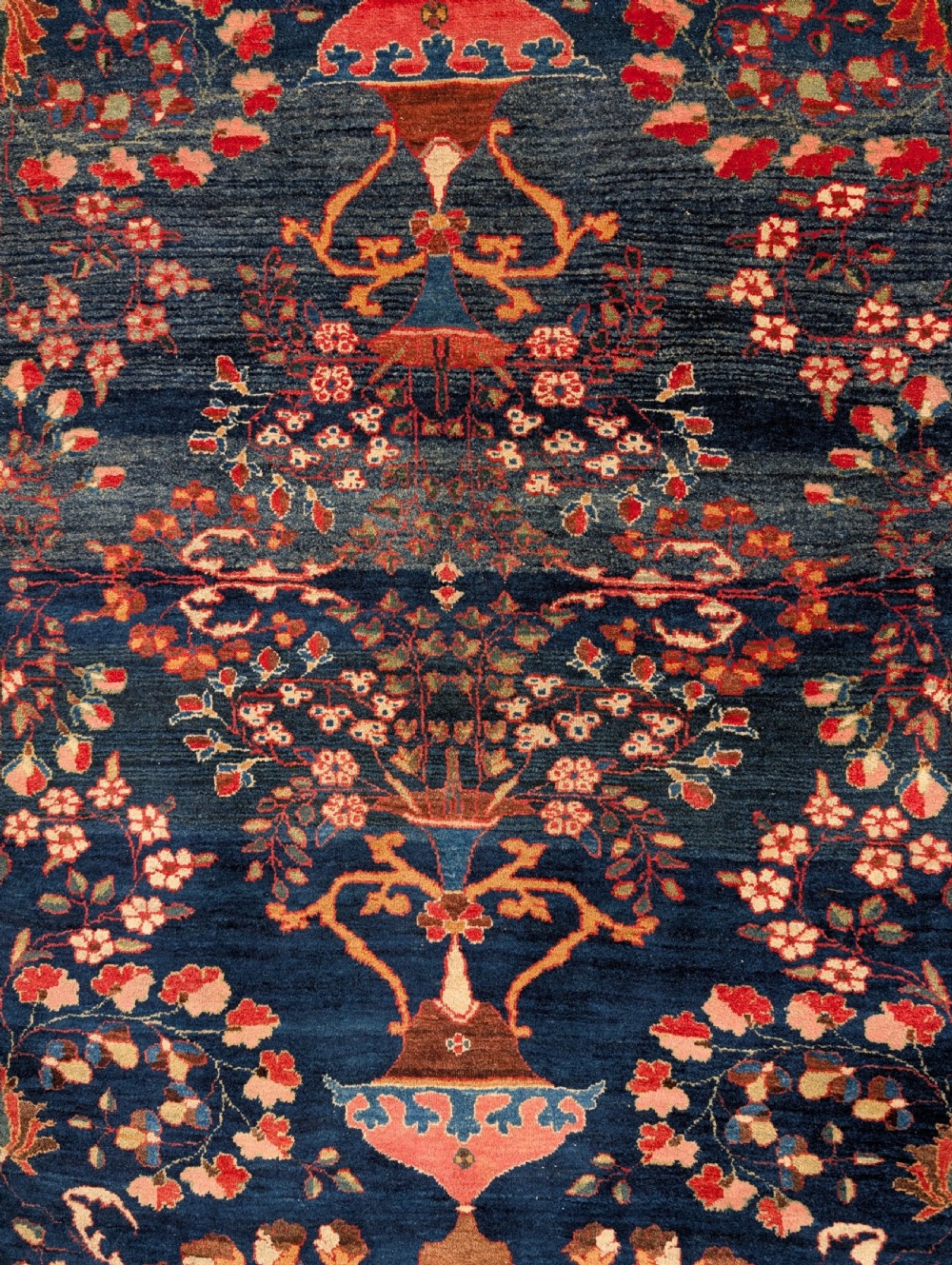 A hand-knotted Persian Kashan wool rug featuring a dark blue field filled with floral vase motifs and framed by a red floral border. View II
