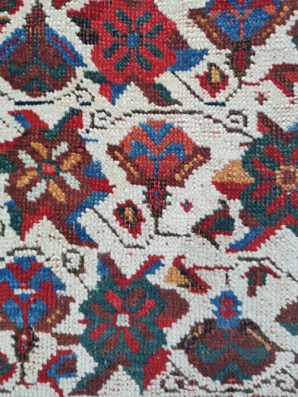 An antique hand-knotted Afshar wool rug featuring a cream field with repeating red and navy geometric motifs framed by a dark red patterned border. View VI
