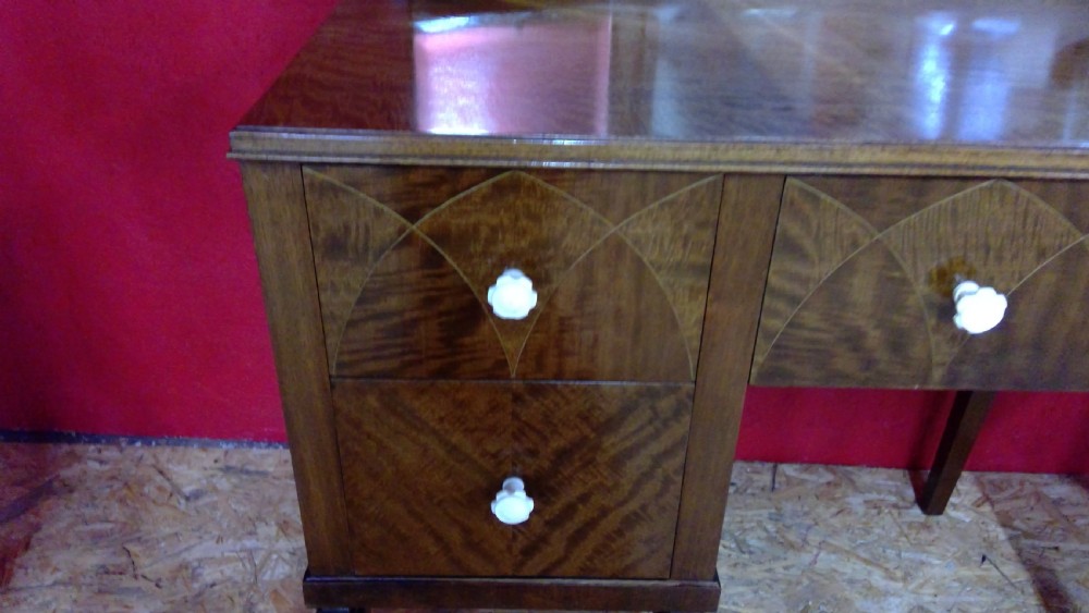 An Art Deco mahogany dressing table featuring a central mirror flanked by two adjustable wing mirrors, geometric wood inlays, and small white drawer knobs. View III