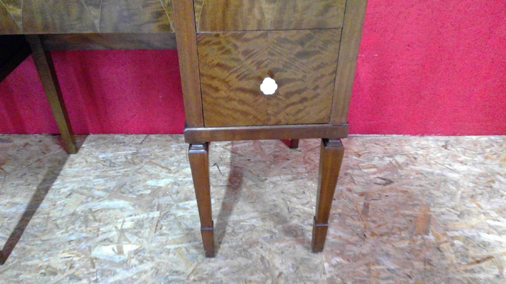 An Art Deco mahogany dressing table featuring a central mirror flanked by two adjustable wing mirrors, geometric wood inlays, and small white drawer knobs. View IV