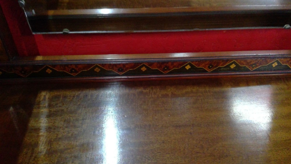 An Art Deco mahogany dressing table featuring a central mirror flanked by two adjustable wing mirrors, geometric wood inlays, and small white drawer knobs. View VII
