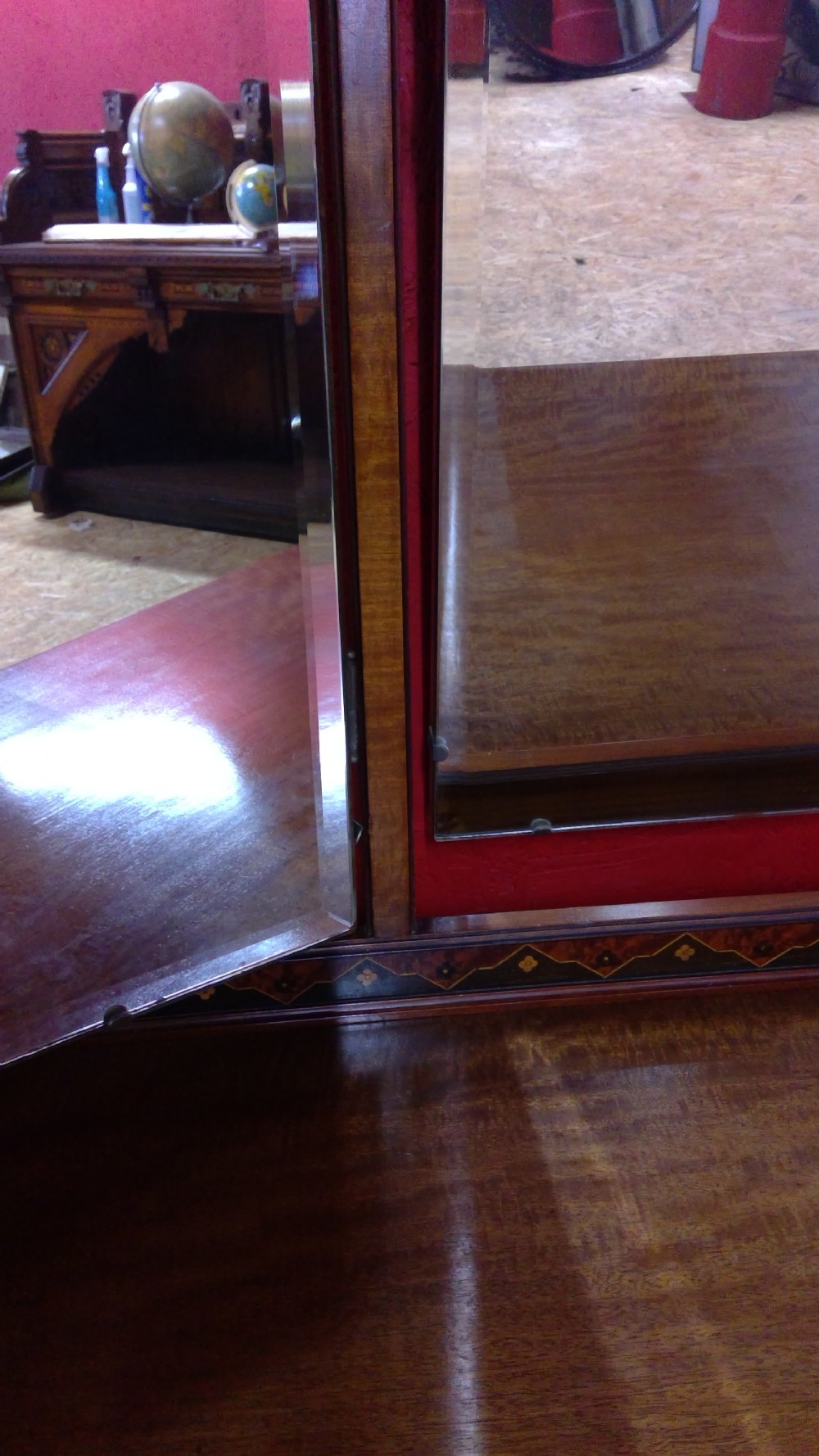 An Art Deco mahogany dressing table featuring a central mirror flanked by two adjustable wing mirrors, geometric wood inlays, and small white drawer knobs. View IX