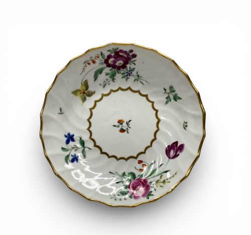 fig 1. An 18th-century Worcester porcelain tea trio comprising a teacup, tea bowl, and saucer with hand-painted floral sprays and gilded spiralled moulding.
