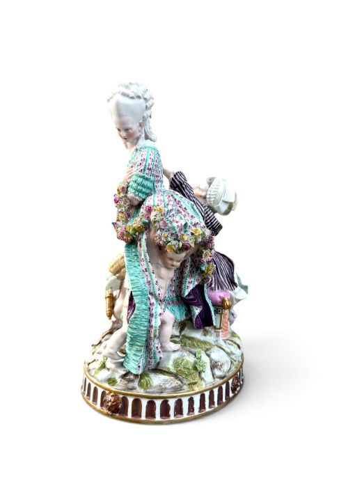 fig 2. An eighteenth-century polychrome hard-paste porcelain figurine group depicting two classical figures and a cherub beside an overturned basket of eggs on a moulded fluted base.
