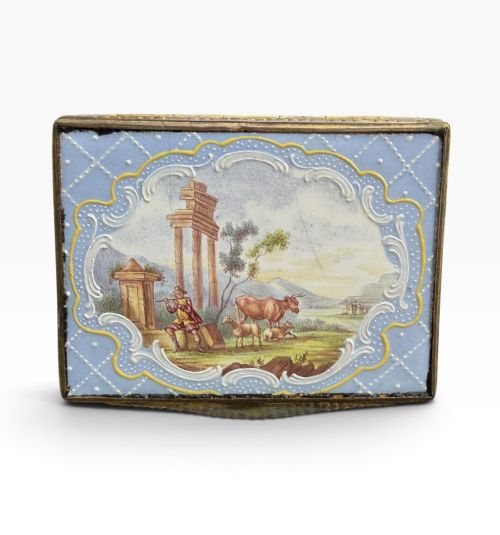 fig 1. A rectangular Georgian enamel snuff box featuring a light blue trellis background, gilt metal mounts, and hand-painted pastoral scenes in central cartouches.