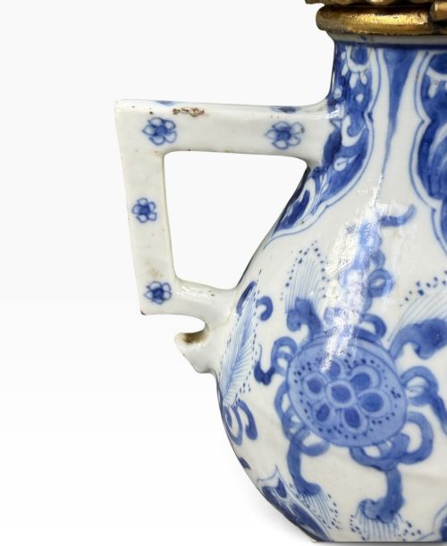 A blue and white Kangxi period Chinese porcelain jug with hand-painted floral decoration, an angular ceramic handle, and a chased gilt-metal lid. View XIII