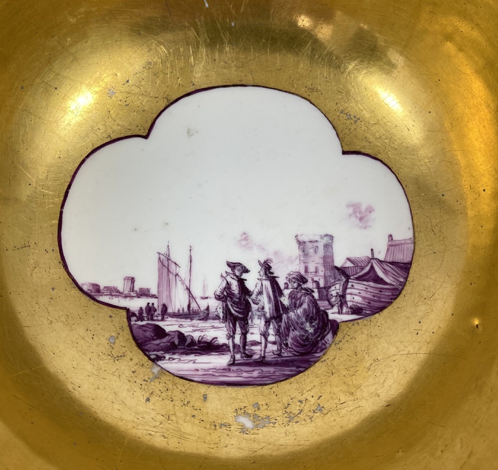 A deep porcelain bowl with a vibrant puce exterior featuring a shaped gilded frame around a hand-painted scene of two figures outdoors. View VIII