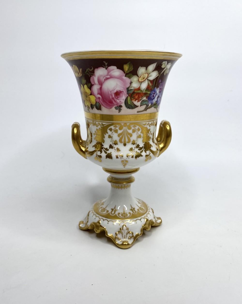 A pair of Royal Crown Derby porcelain urns featuring elaborate gold scrollwork and detailed hand-painted floral bands. View III