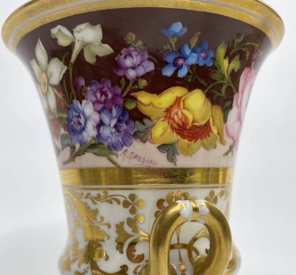 A pair of Royal Crown Derby porcelain urns featuring elaborate gold scrollwork and detailed hand-painted floral bands. View VII
