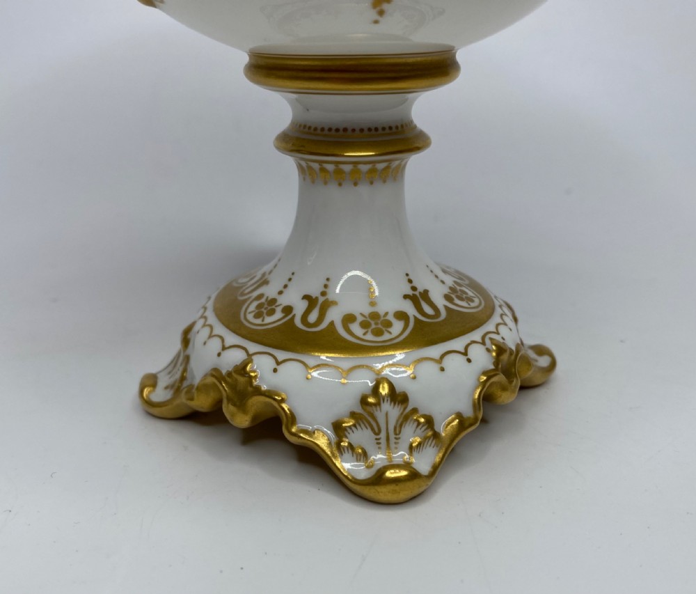 A pair of Royal Crown Derby porcelain urns featuring elaborate gold scrollwork and detailed hand-painted floral bands. View XIII