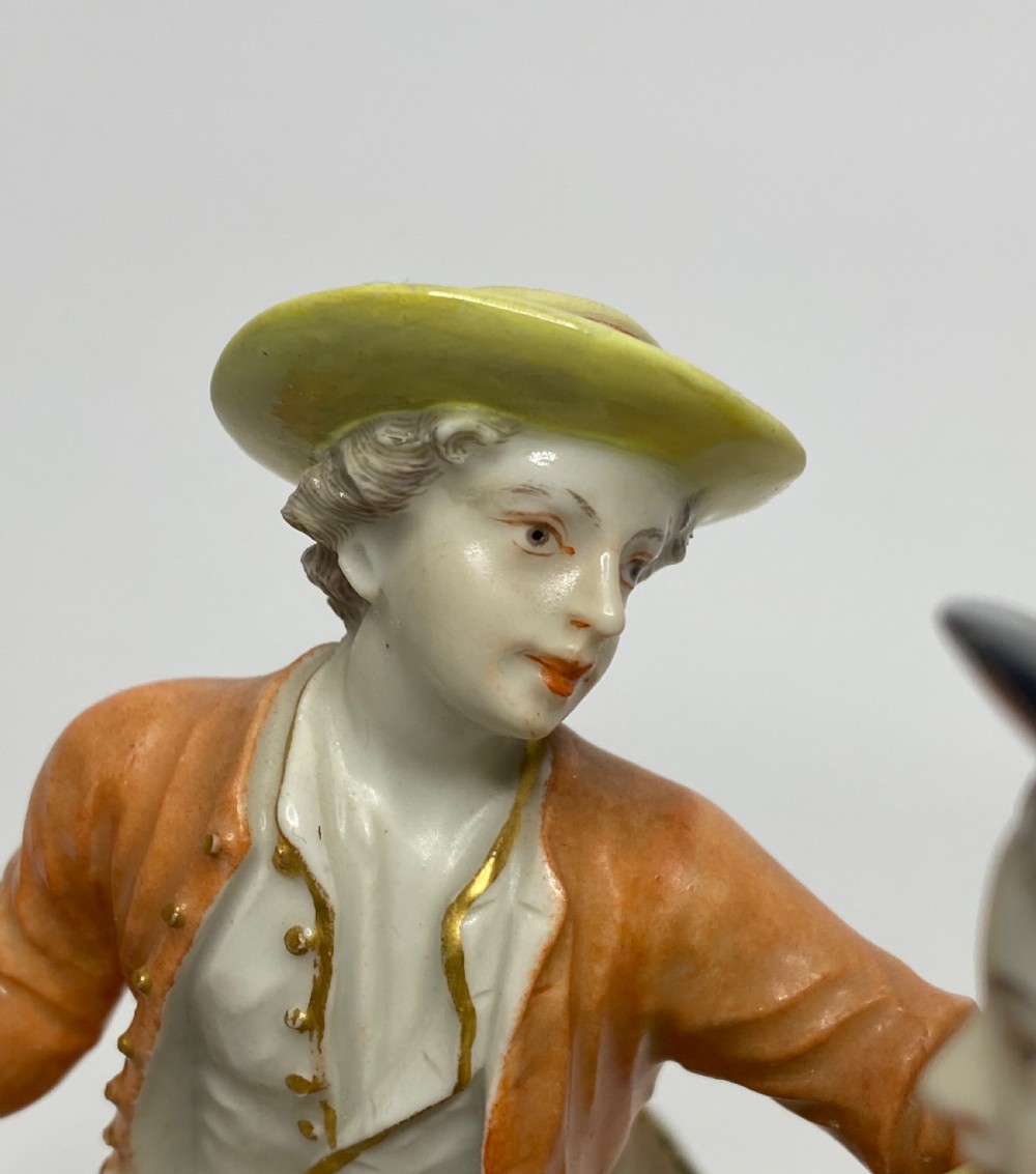 An eighteenth-century Ludwigsburg polychrome porcelain figurine group featuring a man with a wind instrument and a woman seated on a gilded rococo scroll base. View VI