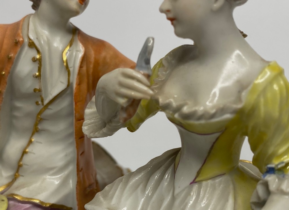 An eighteenth-century Ludwigsburg polychrome porcelain figurine group featuring a man with a wind instrument and a woman seated on a gilded rococo scroll base. View VIII