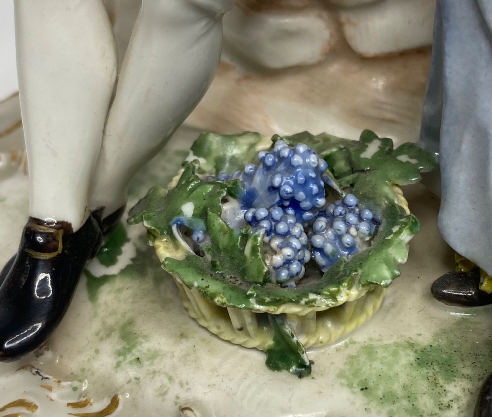 An eighteenth-century Ludwigsburg polychrome porcelain figurine group featuring a man with a wind instrument and a woman seated on a gilded rococo scroll base. View IX