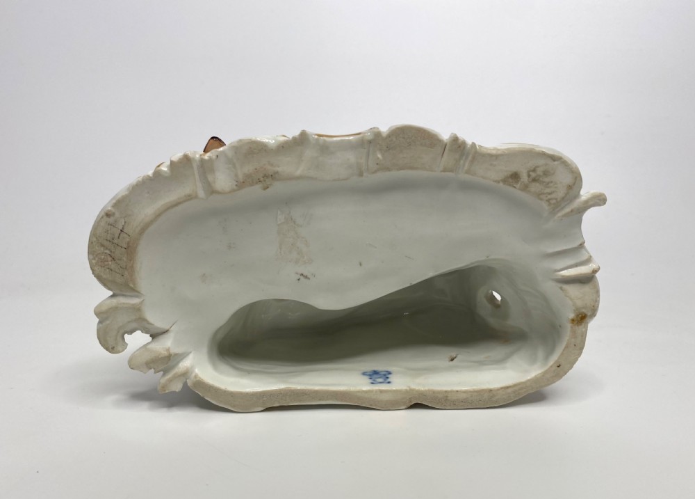 An eighteenth-century Ludwigsburg polychrome porcelain figurine group featuring a man with a wind instrument and a woman seated on a gilded rococo scroll base. View XI