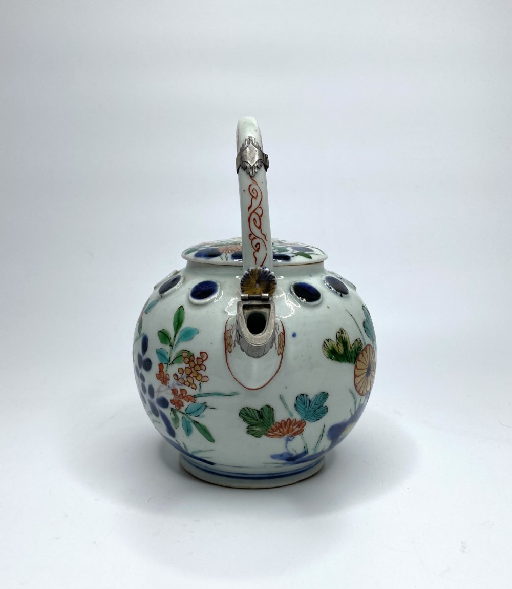 An Edo-period Japanese Imari porcelain sake ewer featuring polychrome floral enamel patterns, an overhead handle, and metal mounts. View II