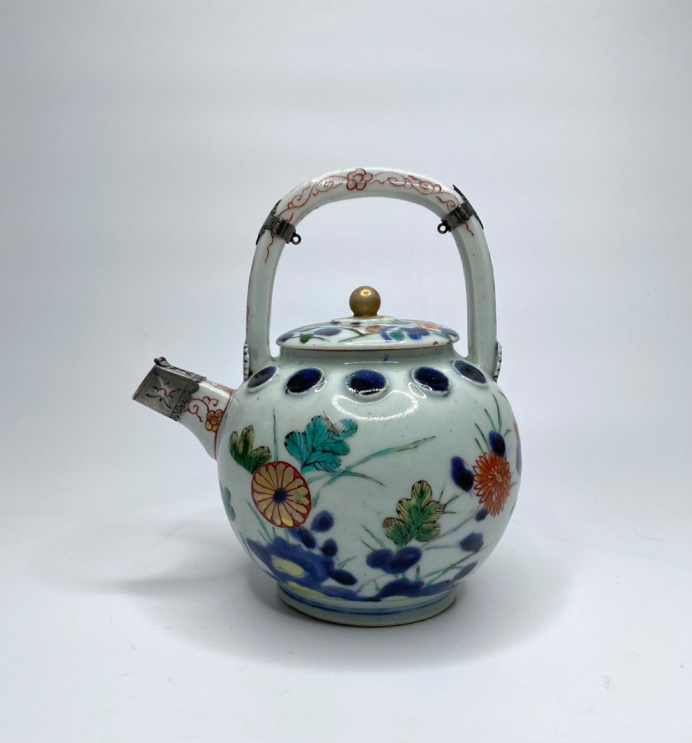 An Edo-period Japanese Imari porcelain sake ewer featuring polychrome floral enamel patterns, an overhead handle, and metal mounts. View III