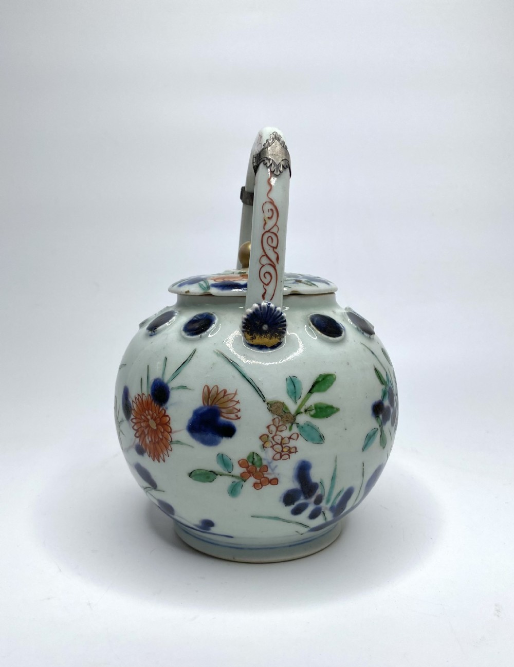 An Edo-period Japanese Imari porcelain sake ewer featuring polychrome floral enamel patterns, an overhead handle, and metal mounts. View V